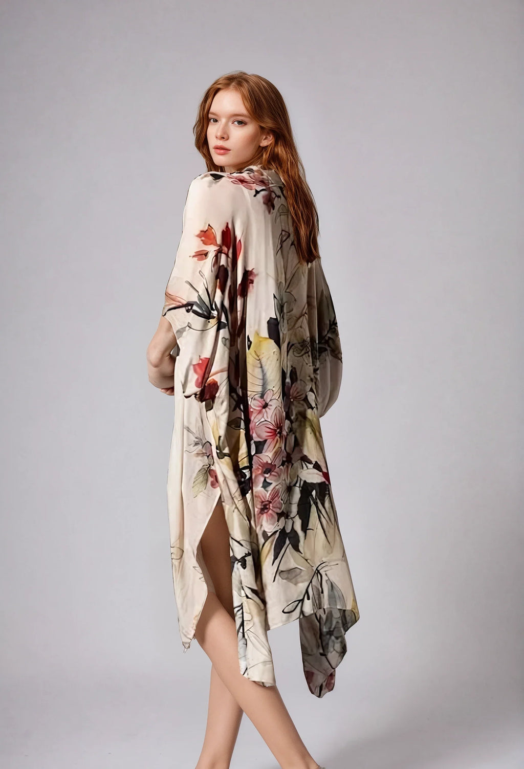 Woman wearing floral patterned Fleur Serenity Kimono with side slit, posing against a plain grey background.
