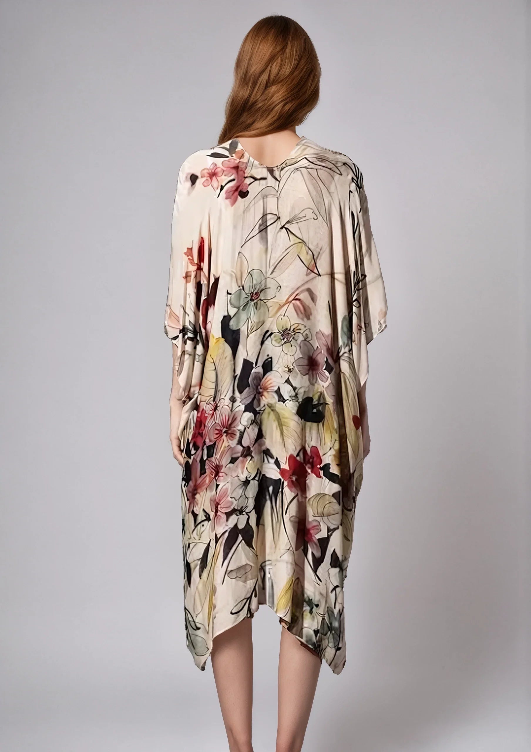 Woman wearing a floral patterned cream Fleur Serenity Kimono shown from the back with loose flowing sleeves.