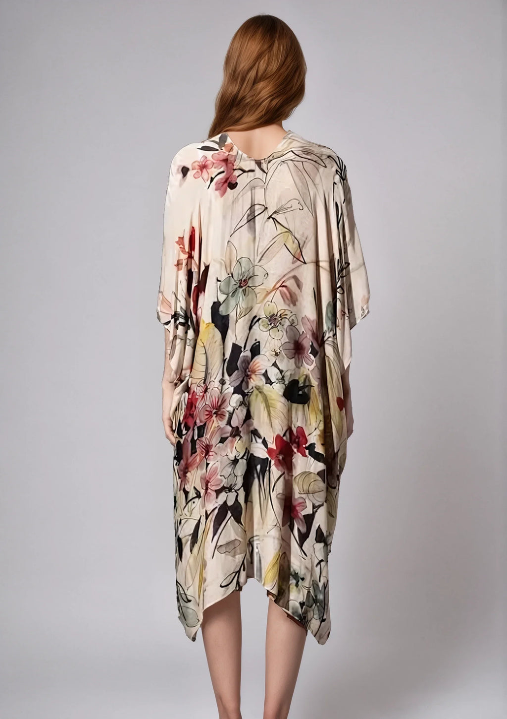 Back view of a woman wearing a flowing floral print Fleur Serenity Kimono with soft pastel colors.