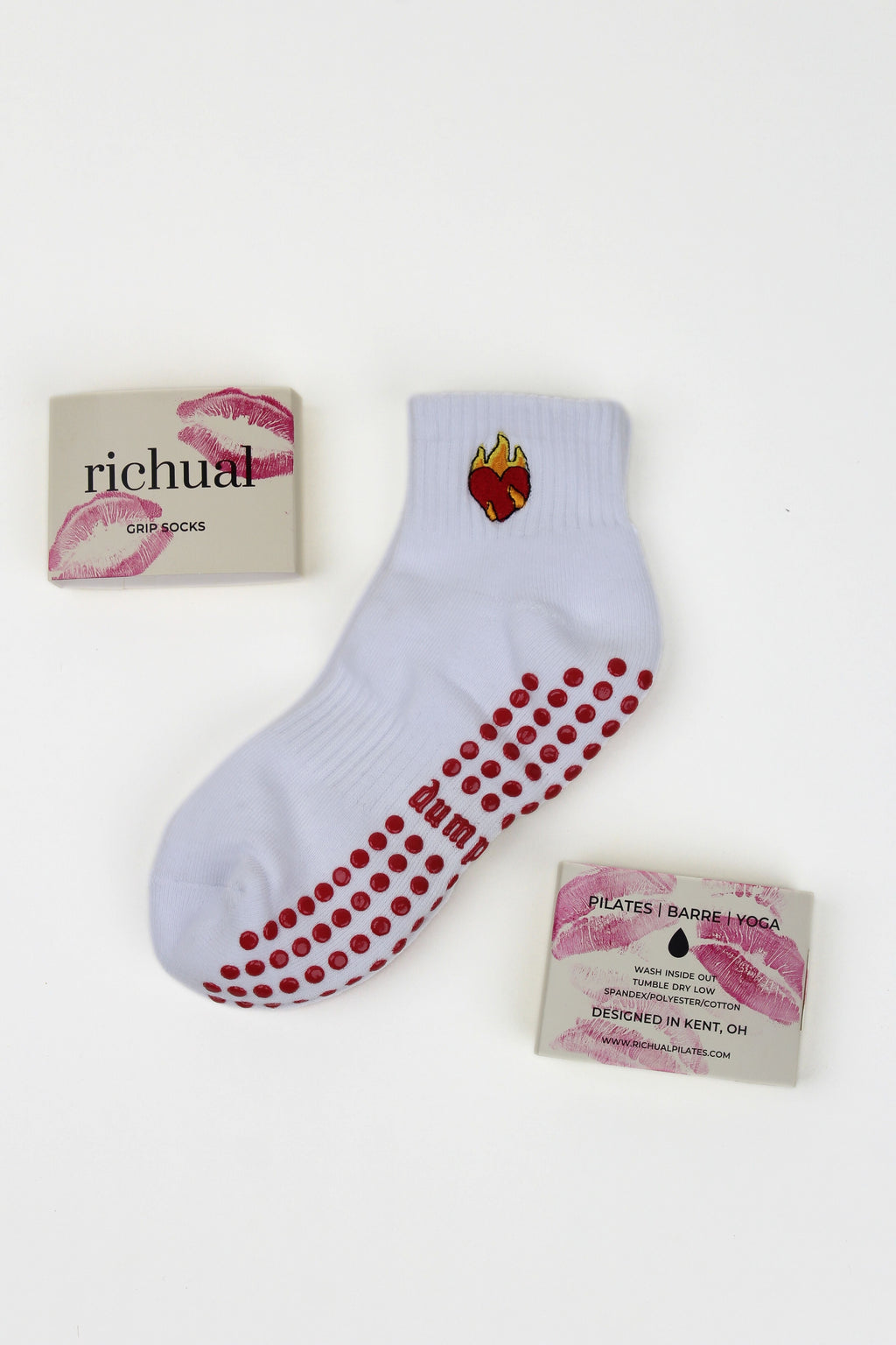 White ankle Dump Him Grip Socks with red grip dots and a flaming broken heart design on cuff