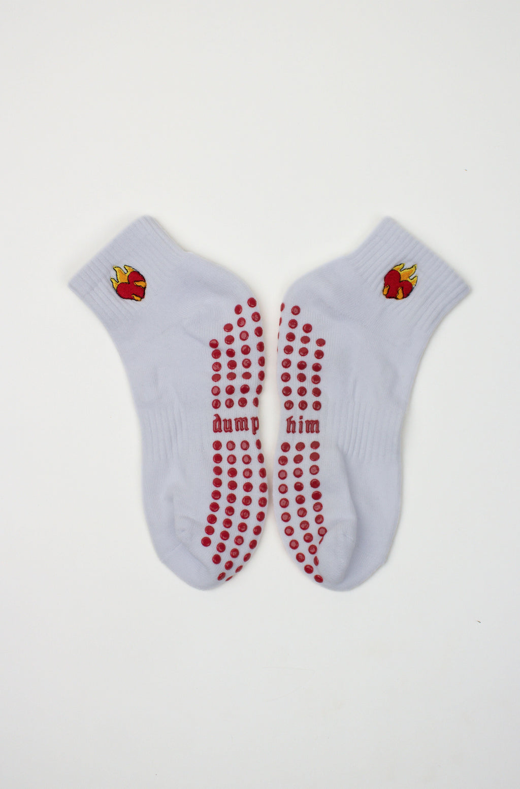 White ankle Dump Him Grip Socks with red grip dots and flaming heart design near the cuff