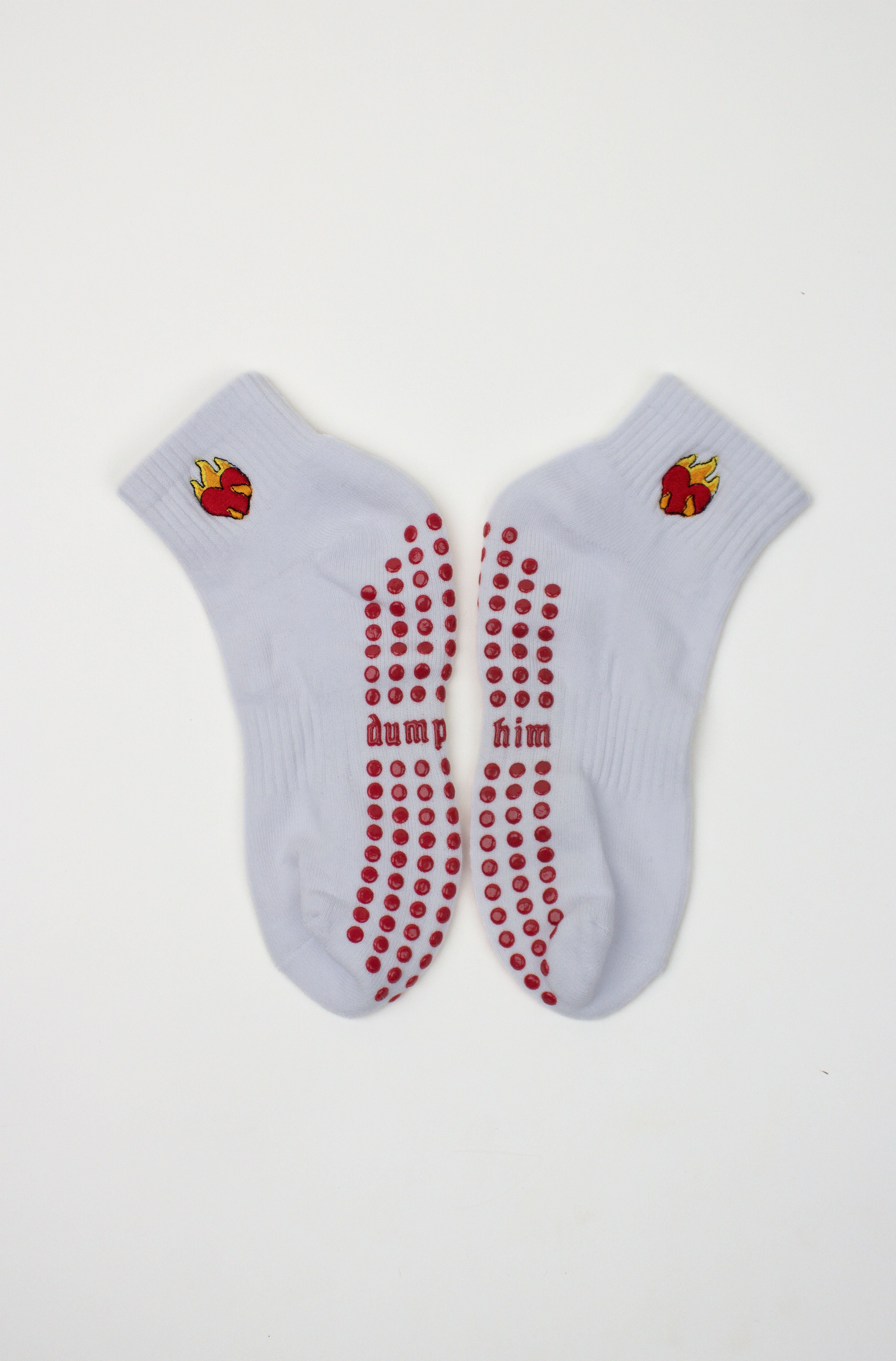 White ankle Dump Him Grip Socks with red grip dots and flaming heart design near the cuff