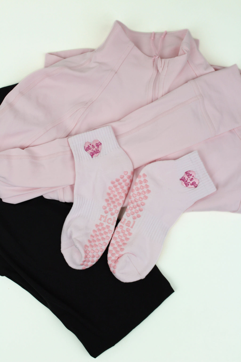 PREORDER: Let's Go Girls Grip Socks in white with pink hearts and logo, displayed on pink and black activewear layers