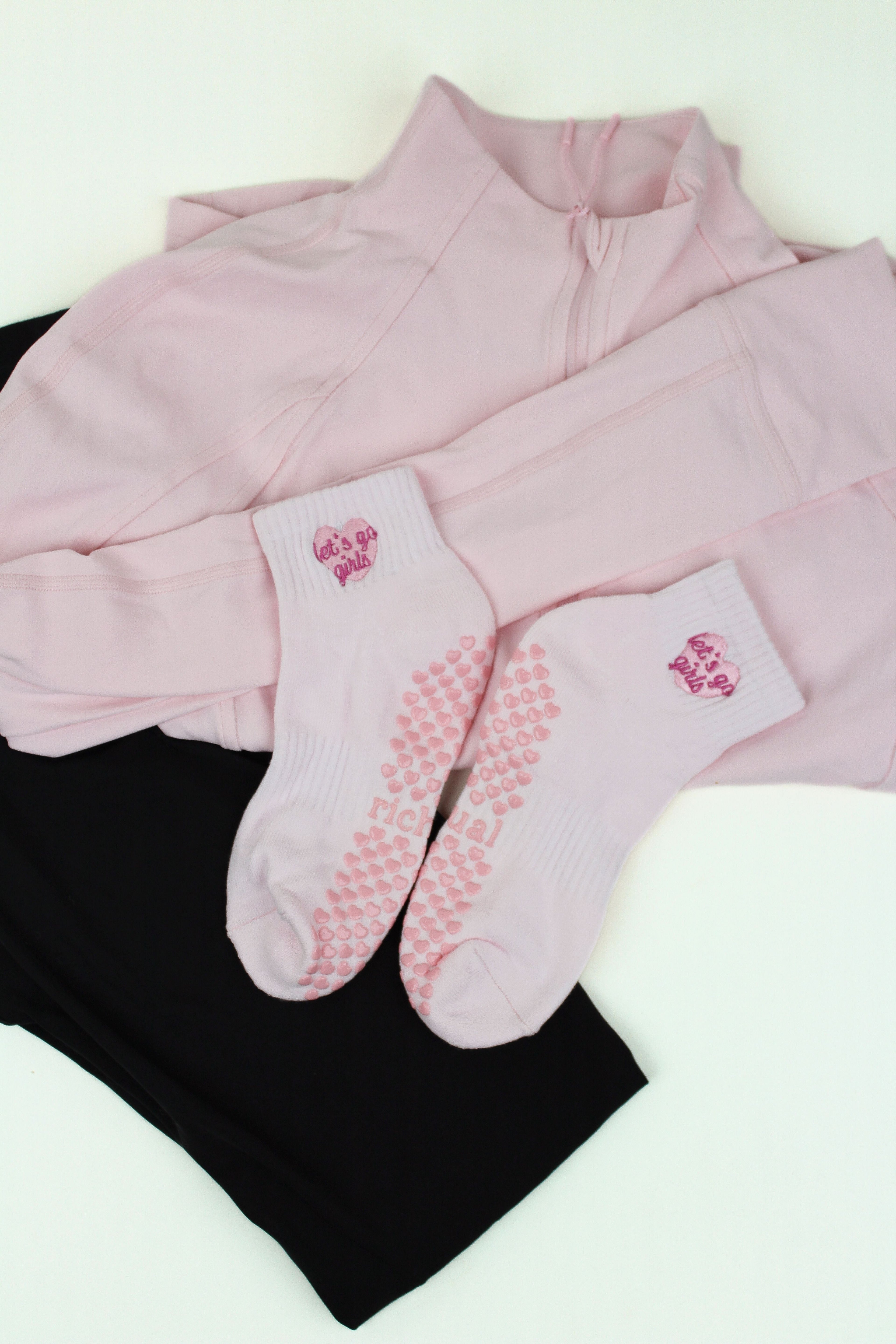 PREORDER: Let's Go Girls Grip Socks in white with pink hearts and logo, displayed on pink and black activewear layers