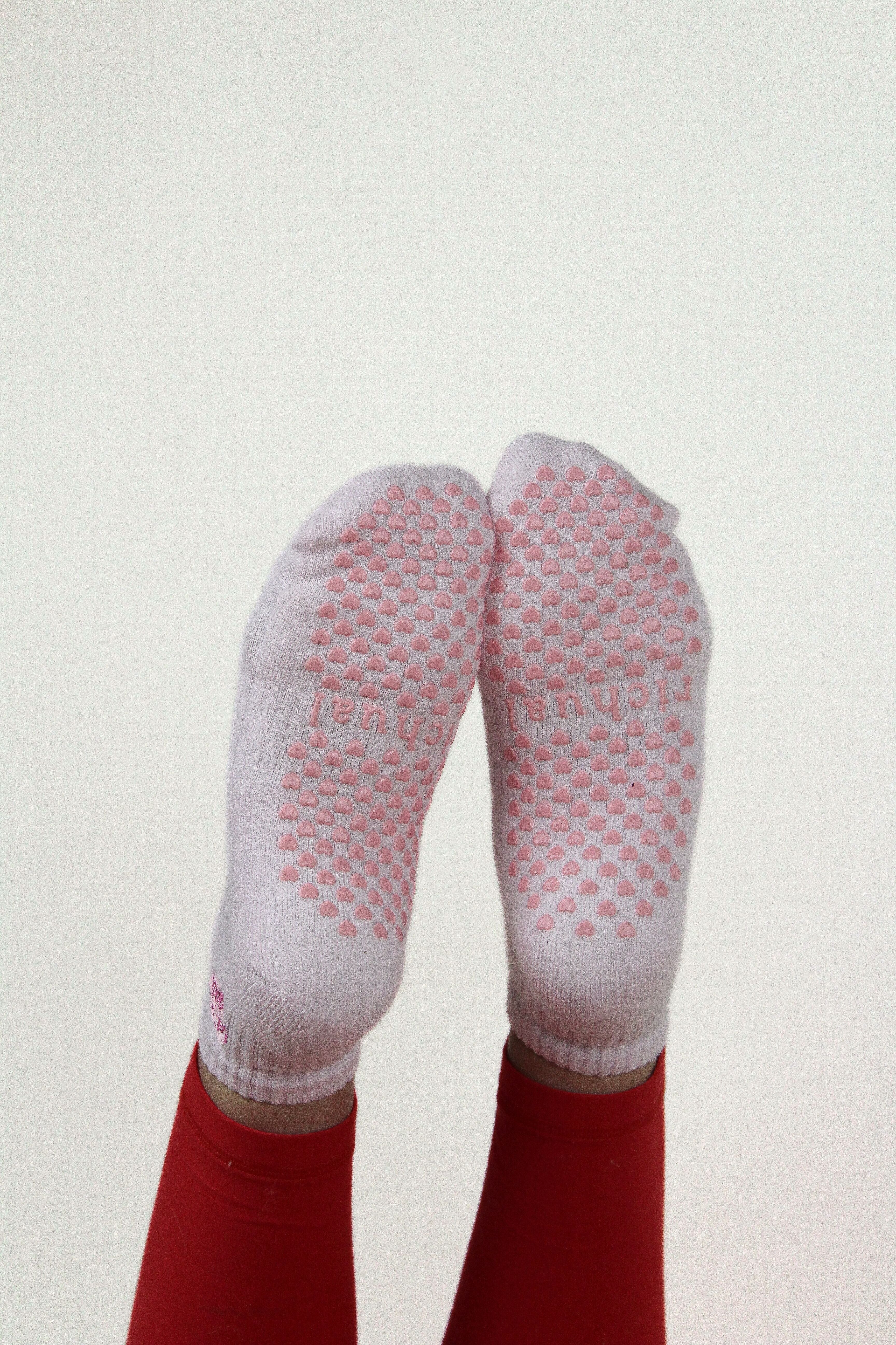 Feet wearing pink and white non-slip grip socks with heart patterns, PREORDER: Let's Go Girls Grip Socks visible below ankles